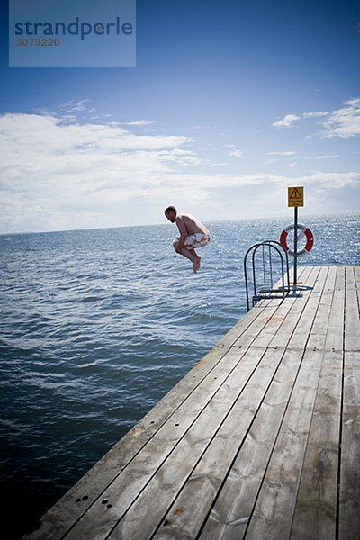 A man going for a swim Skane Sweden.