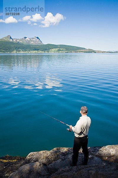 Man fishing in the fiord Gratangen Norway.