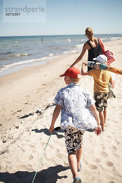 Mother and sons walking on a beach Gotland Sweden.