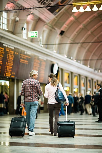 A couple with suitcases at a railway station Sweden.