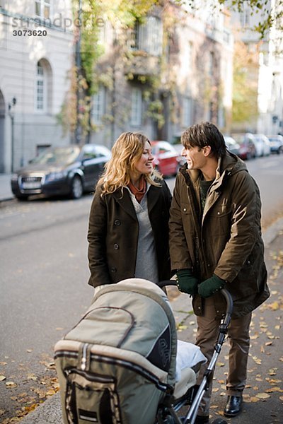 A couple taking a walk with their baby Sweden.