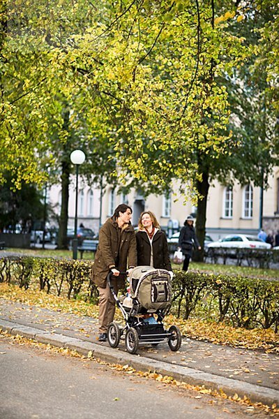 A couple taking a walk with their baby Sweden.