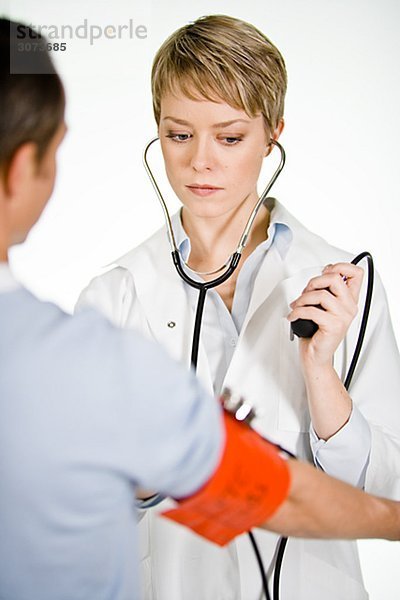 A female doctor using a blood-pressure gauge Sweden.