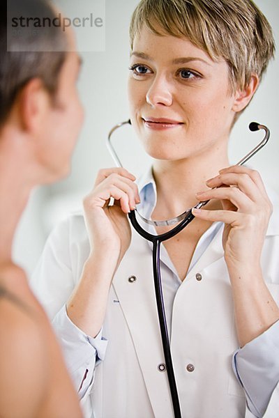 A doctor using a stethoscope at a patient Sweden.