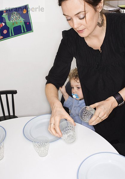 Eine Mutter Esstisch von ihrem Sohn Schweden festlegen.