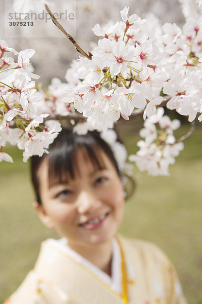 Japanische Frau lächelnd betrachten Kirschenblüten