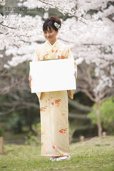 Japanische Frau Standing hält weiße Tafel