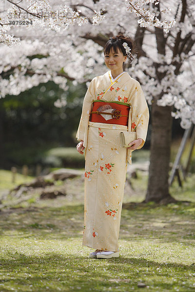 Frau in Kimono Standing hält Clutch Handtasche