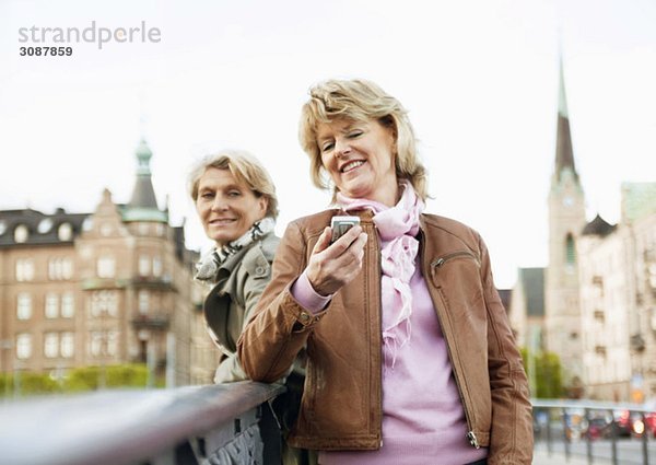 Frauen auf Brücke mit Handy