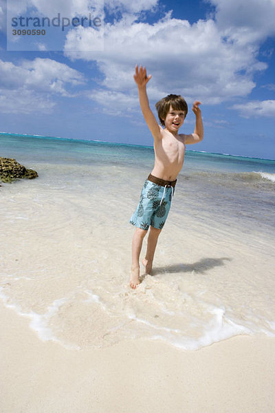 Ein kleiner Junge springt am Strand  Cable Beach  Nassau  Bahamas  Karibik