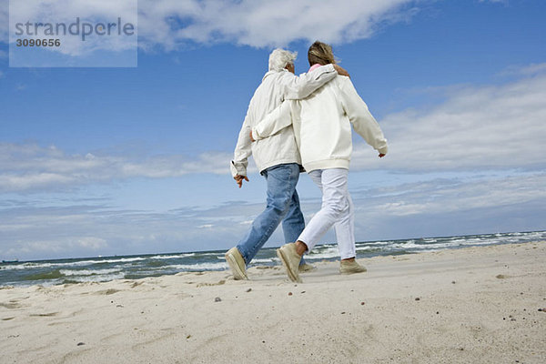 Ein älteres Paar  das am Strand spazieren geht.