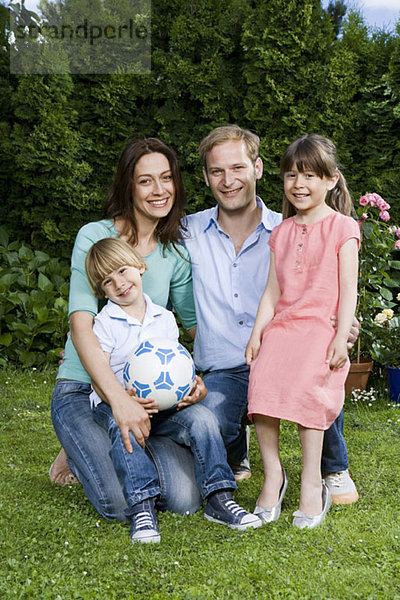 Ein Porträt eines mittleren erwachsenen Paares und seiner zwei kleinen Kinder