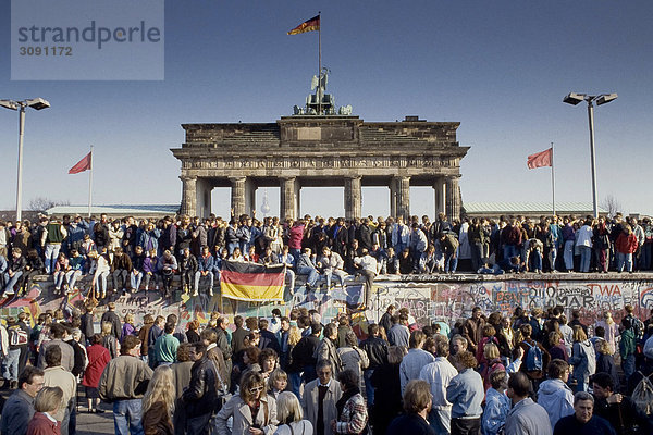 Fall der Berliner Mauer: Menschen aus Ost- und West-Berlin sind auf die Mauer am Brandenburger Tor geklettert. Berlin  Deutschland|