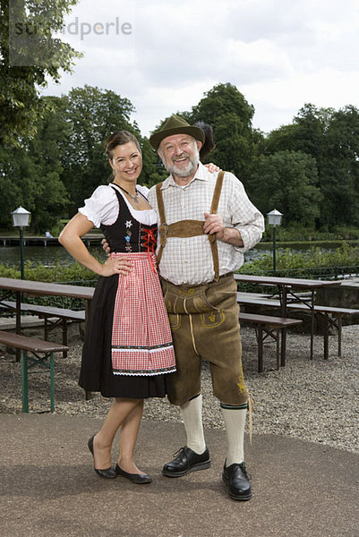 Ein traditionell gekleideter deutscher Mann und Frau in einem Biergarten