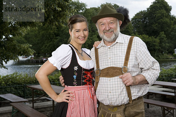 Ein traditionell gekleideter deutscher Mann und Frau im Biergarten  Porträt