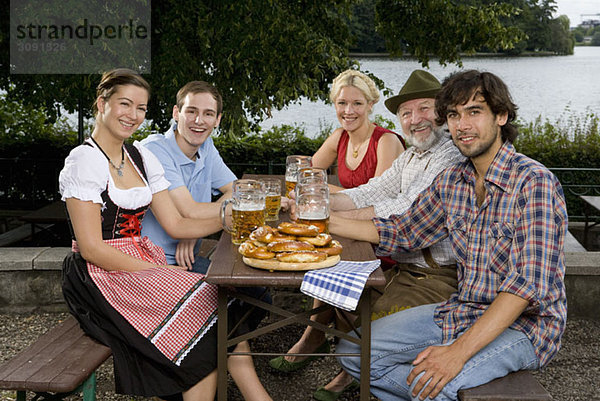 Fünf Personen sitzen in einem Biergarten