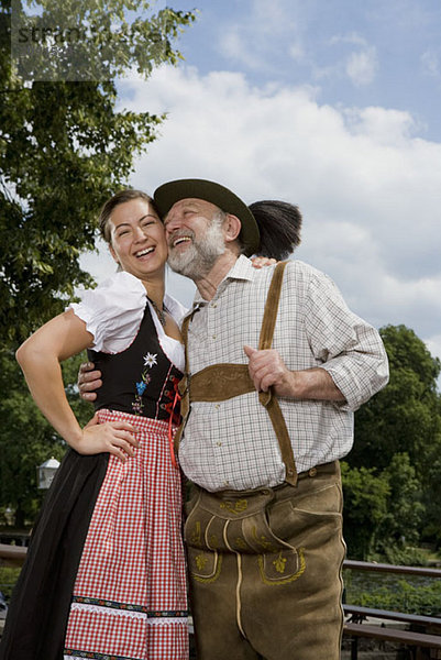 Ein traditionell gekleideter deutscher Mann und Frau in einem Biergarten