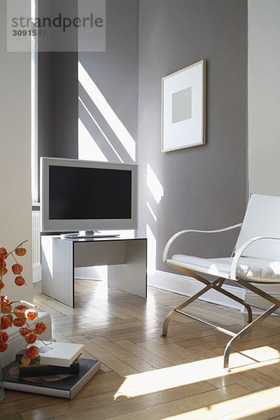 Fernseher und Sessel im modernen Wohnzimmer