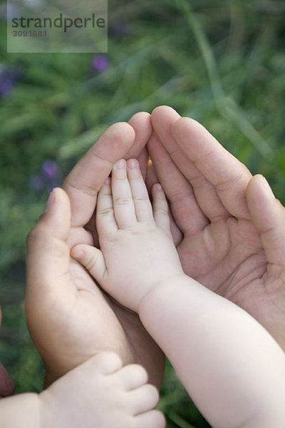 Die Hände eines Babys und eines Erwachsenen