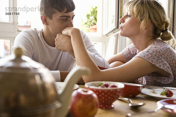 Ein junges Paar sitzt am Frühstückstisch.