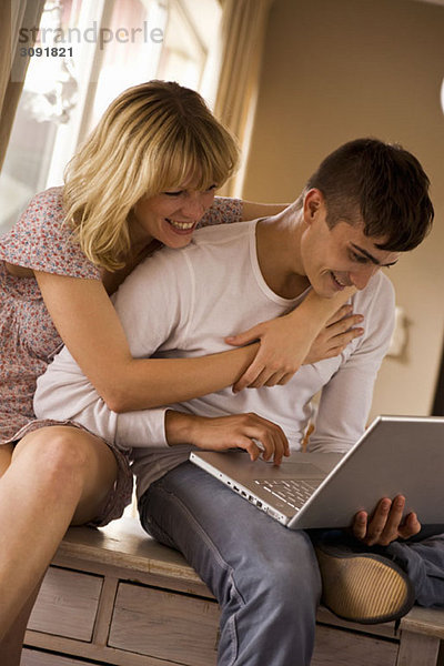 Ein junges Paar mit einem Laptop zusammen