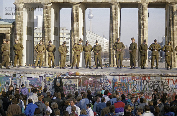 Fall der Berliner Mauer: Grenzsoldaten der nationalen Volksarmee sichern die Mauer am Brandenburger Tor. Berlin  Deutschland