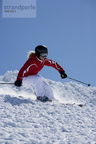 Mädchen in rotem Carving abseits der Piste.