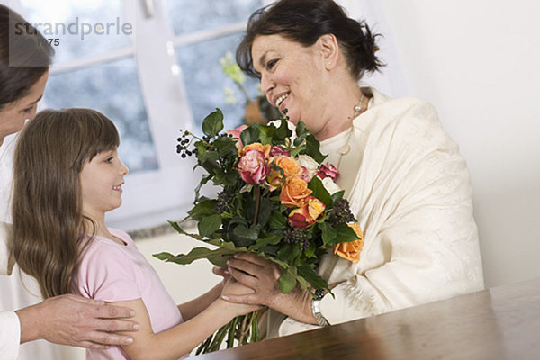 Kind schenkt ihrer Großmutter Blumen