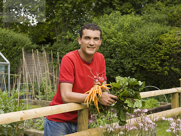 Mann im Garten mit Gemüse