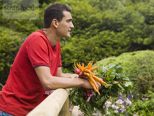 Mann im Garten mit Gemüseanbau