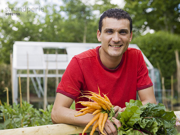 Mann im Garten mit Gemüseanbau