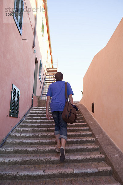 Mann geht die Steintreppe hinauf