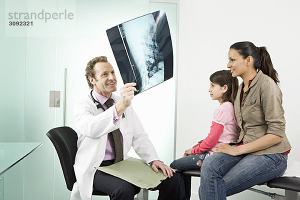 Männlicher Arzt untersucht einen Patienten und Röntgenbild