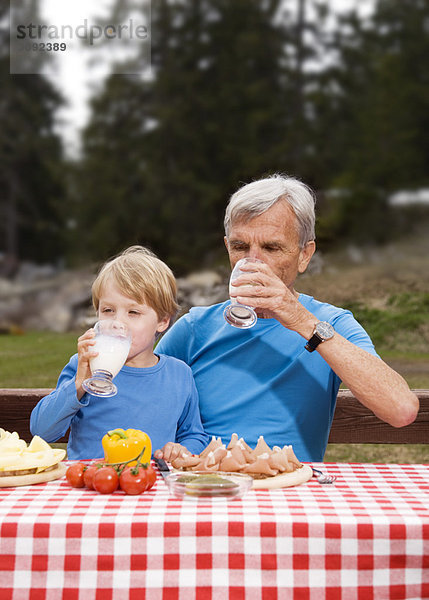 Großvater  Enkel beim Essen in den Bergen