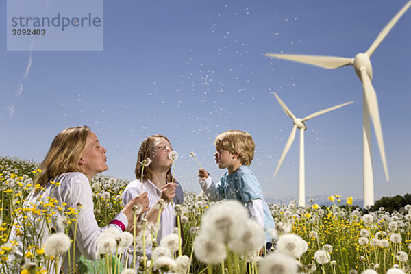 Mädchen und Junge und Mutter an Windkraftanlagen