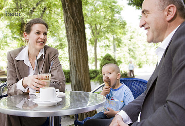 Geschäftspaar mit Sohn im Außencafé