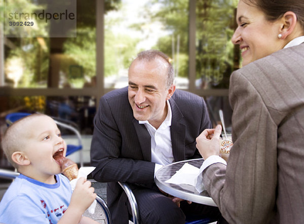 Geschäftspaar mit Sohn im Außencafé