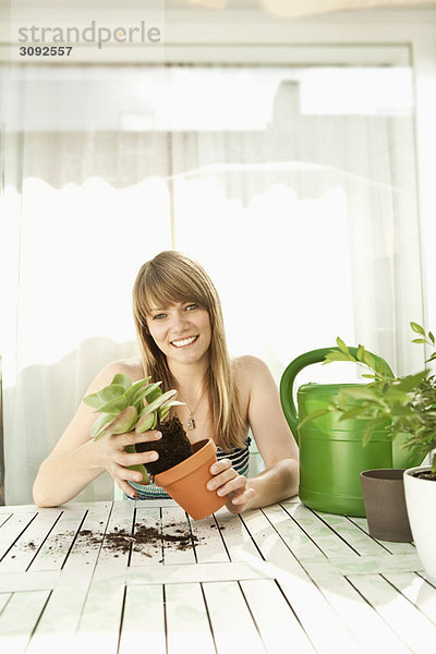 Junge Frau und Pflanzen auf der Terrasse