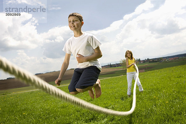 Kinder springen auf dem Land abseilen