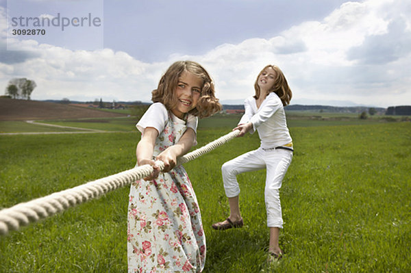 Kinder beim Seilziehen auf dem Land