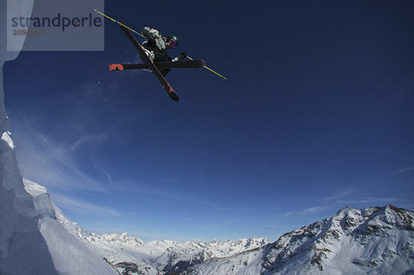 Skifahrer springt in die Luft.