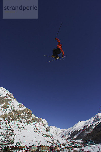 Freestyle-Skifahrer  der durch die Luft springt.