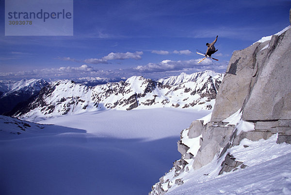 Skifahrer beim Sprung von einer Klippe