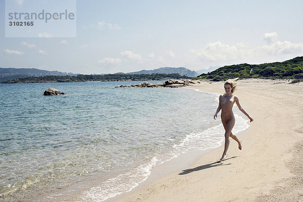 Nackte Frau überspringen am Strand