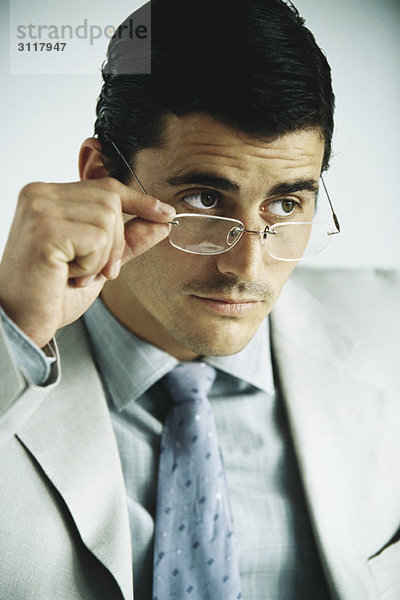 Geschäftsmann schaut weg  senkt Brille  Portrait