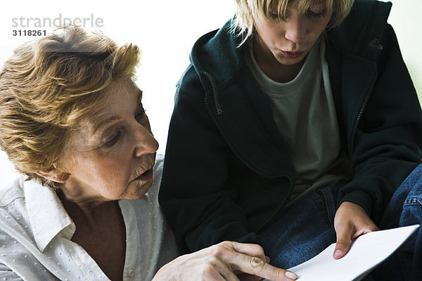 Großmutter hilft Enkel bei den Hausaufgaben