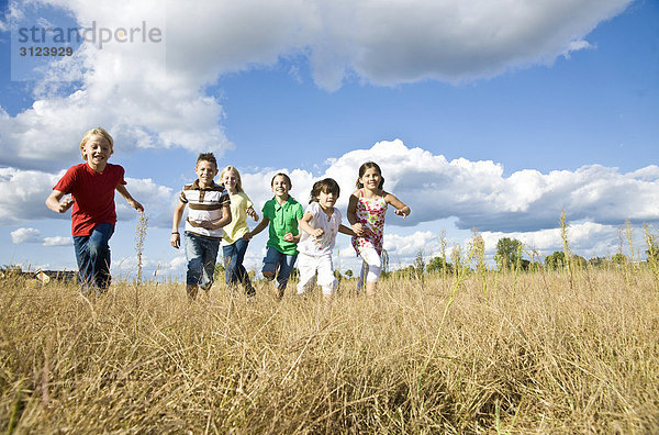 Kinder rennen über ein Feld  Flachwinkelansicht