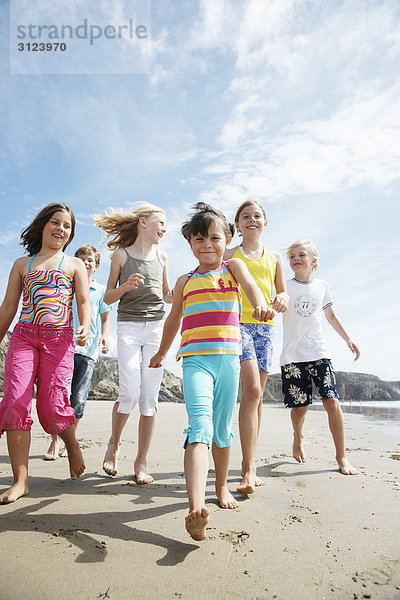 Kinder laufen am Strand  Frontal  Flachwinkelansicht