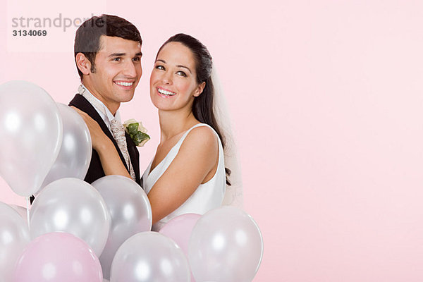 Braut und Bräutigam mit einem Haufen Ballons