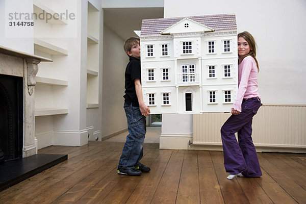 Zwei Kinder mit einem Puppenhaus